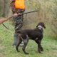 A man stands with weapons and hunting dogs